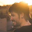 Lucas, sorrindo, ao pôr do sol